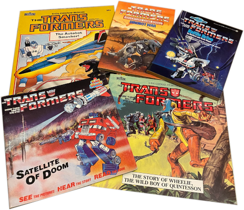 Image of several vintage Transformers books splayed out in a display.